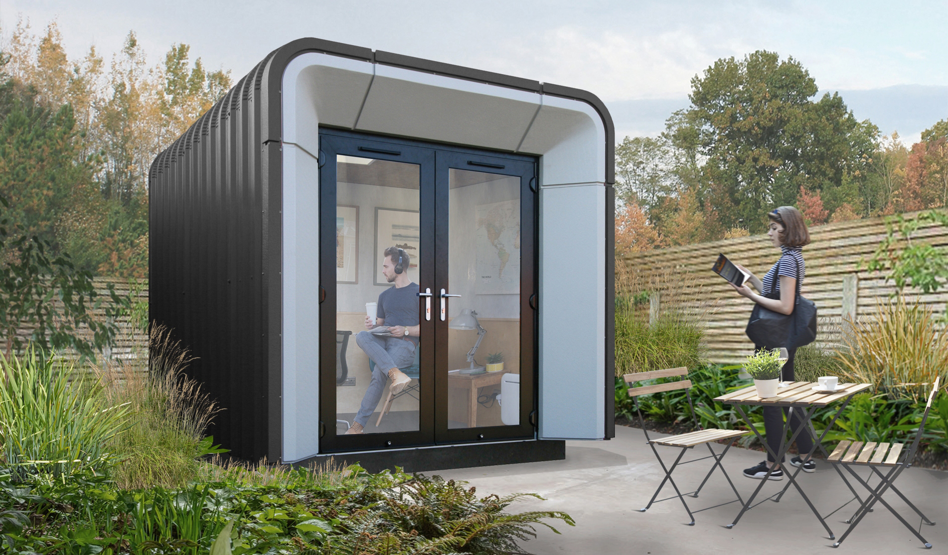 angled view of Rumipod Pico garden office, finished in an Anthracite colour, with man sitting inside and woman standing outside