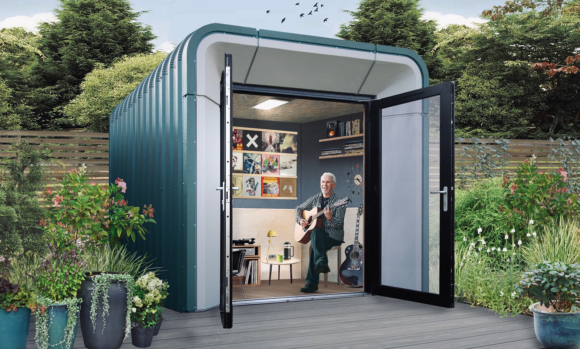 contemporary garden building used as music room with man playing guitar
